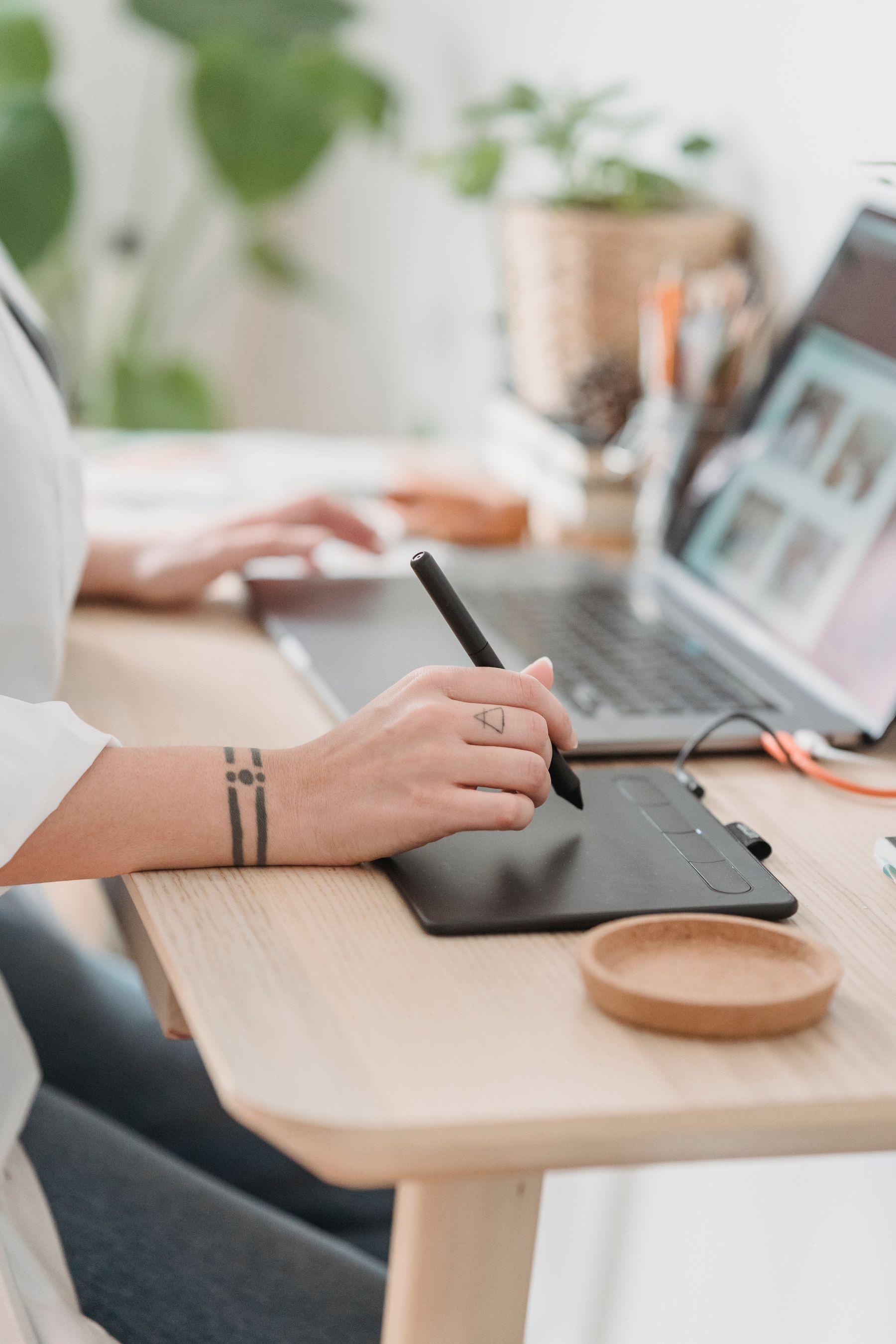 Profissional trabalha em um laptop e tablet.